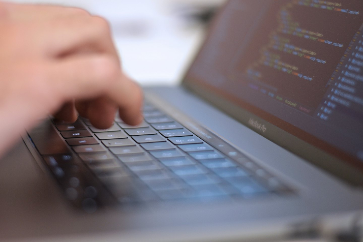 Händer som skriver programmeringskod på ett laptop-tangentbord.